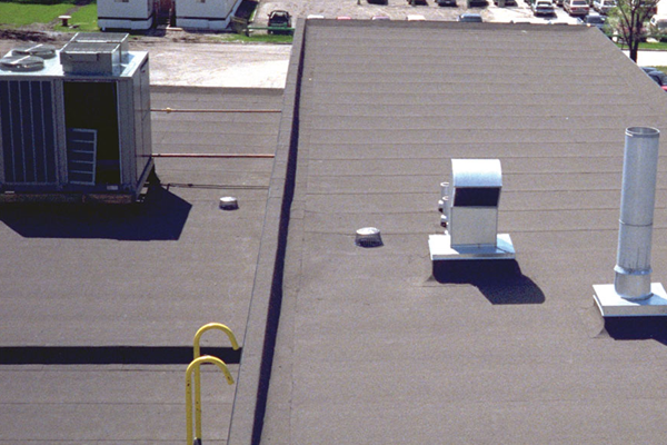 Toit plat avec équipements de ventilation visibles.